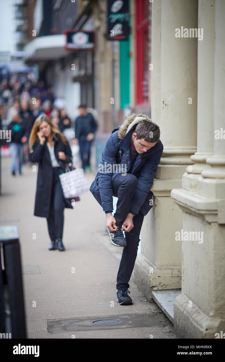 Glasgow in Scotland,  tying  a shoe lase in the street Stock Photo