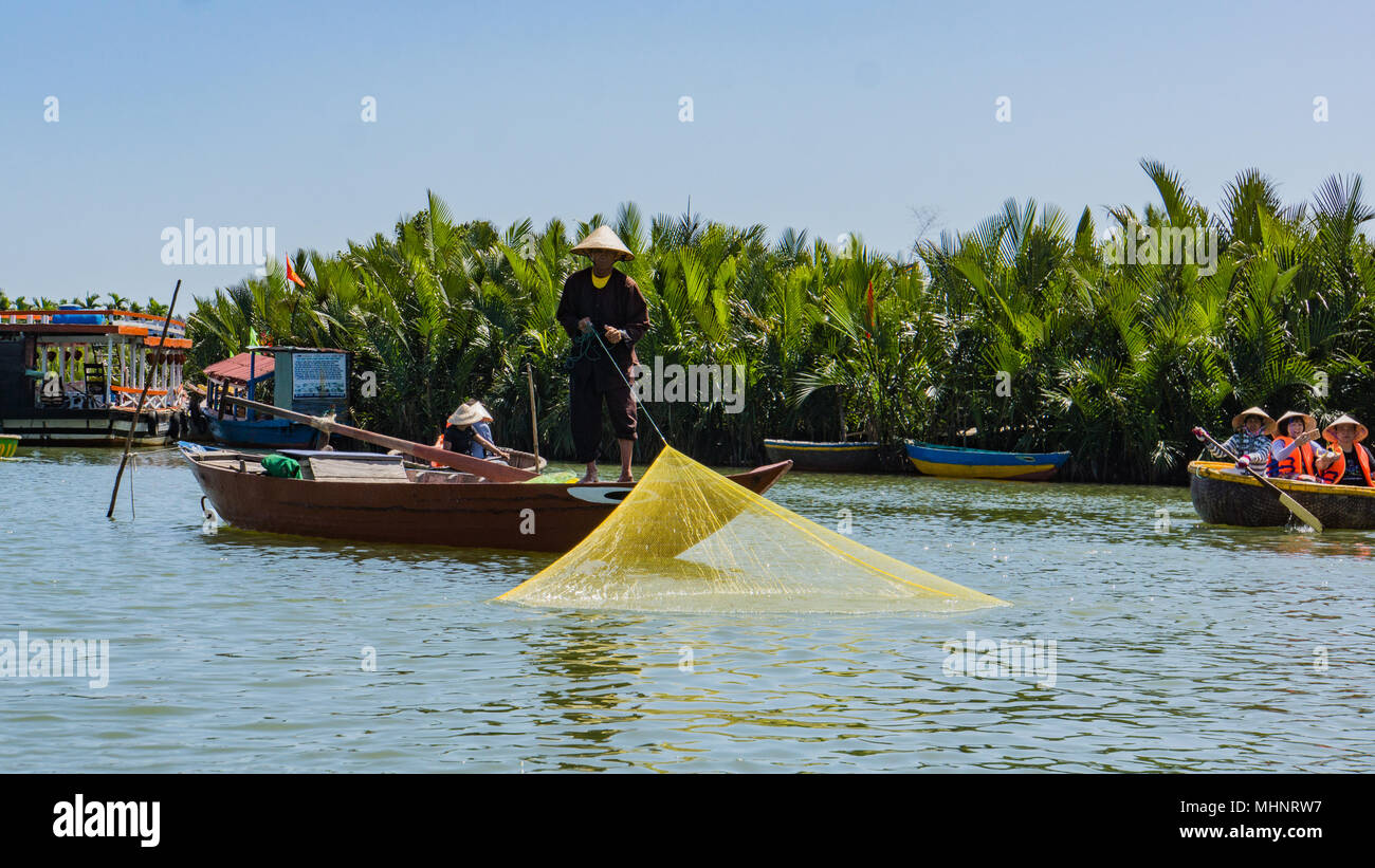 fisherman pulling up his fishing net on the water Stock Photo