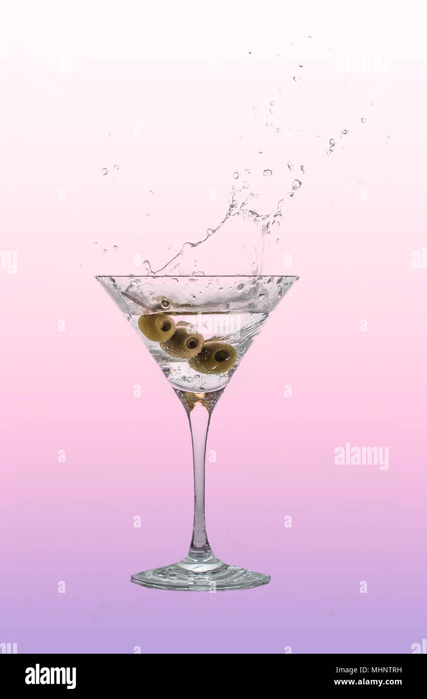 A splash of martini in a cocktail glass with olives. Stock Photo