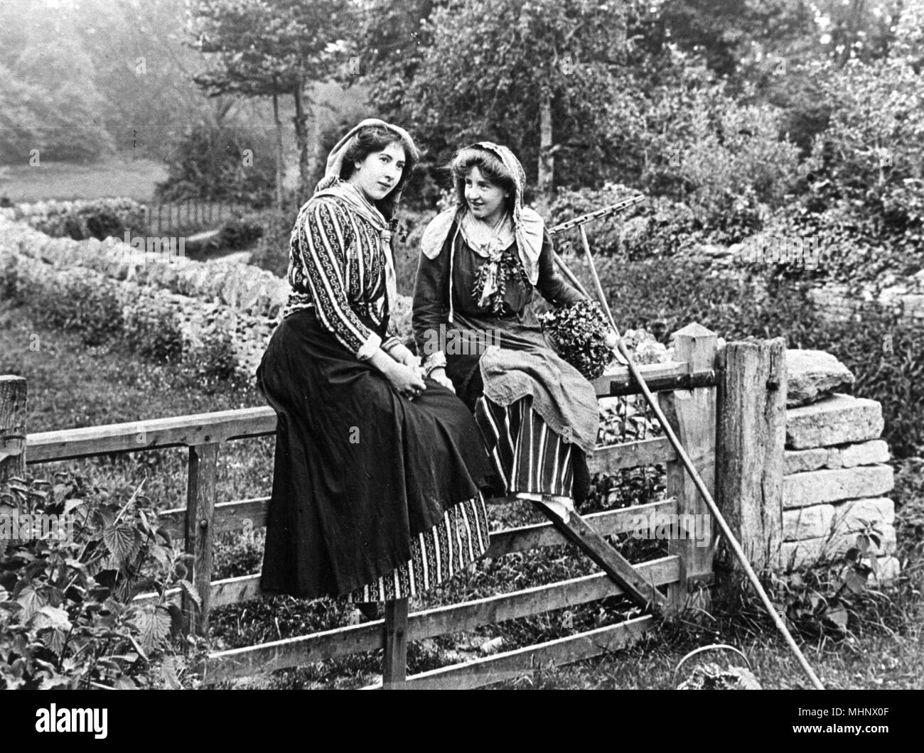 Country girls sitting on a gate, 1890s     Date: 1890s Stock Photo
