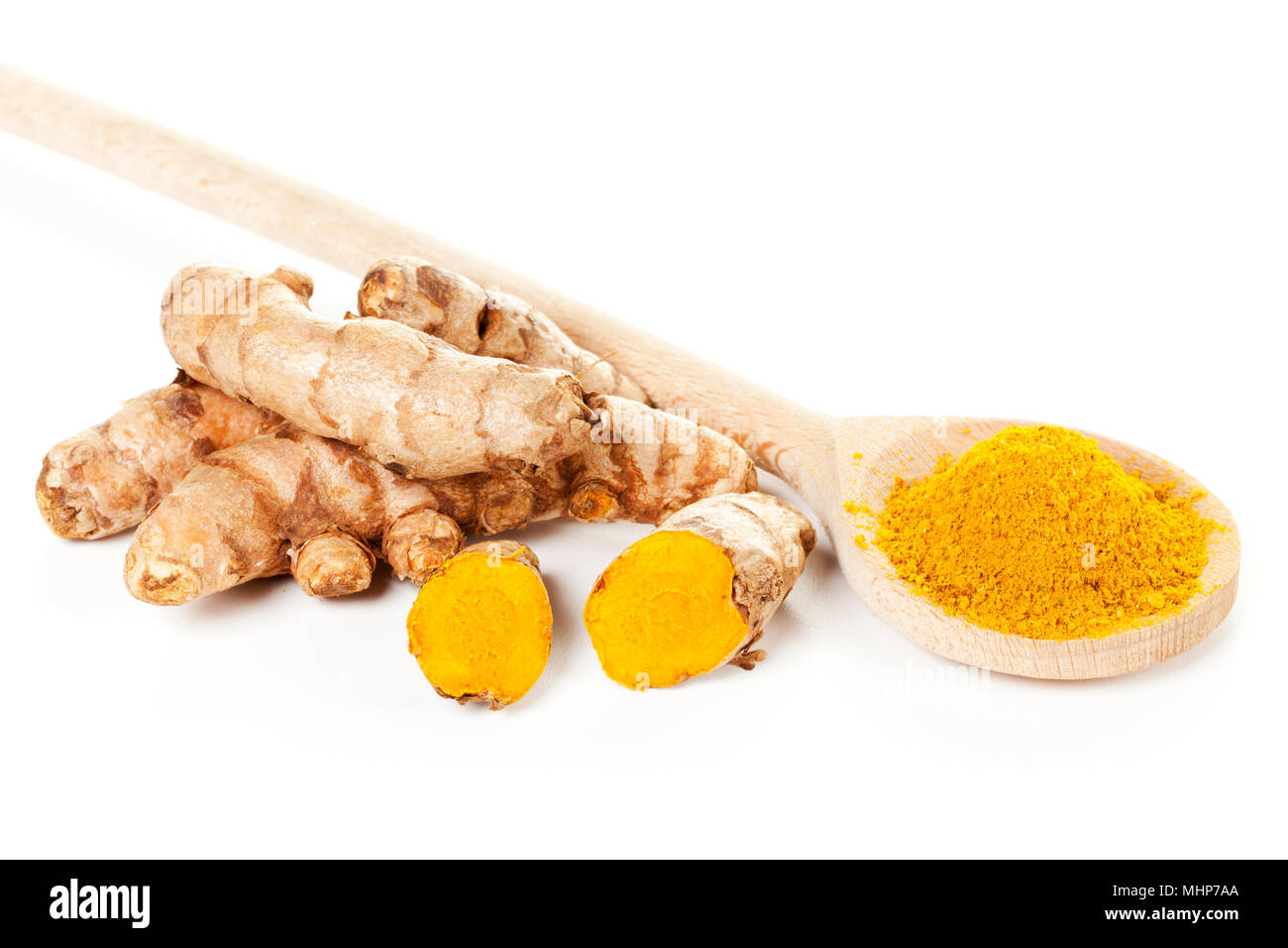 Turmeric rhizomes and ground turmeric on wooden spoon, isolated on white background Stock Photo