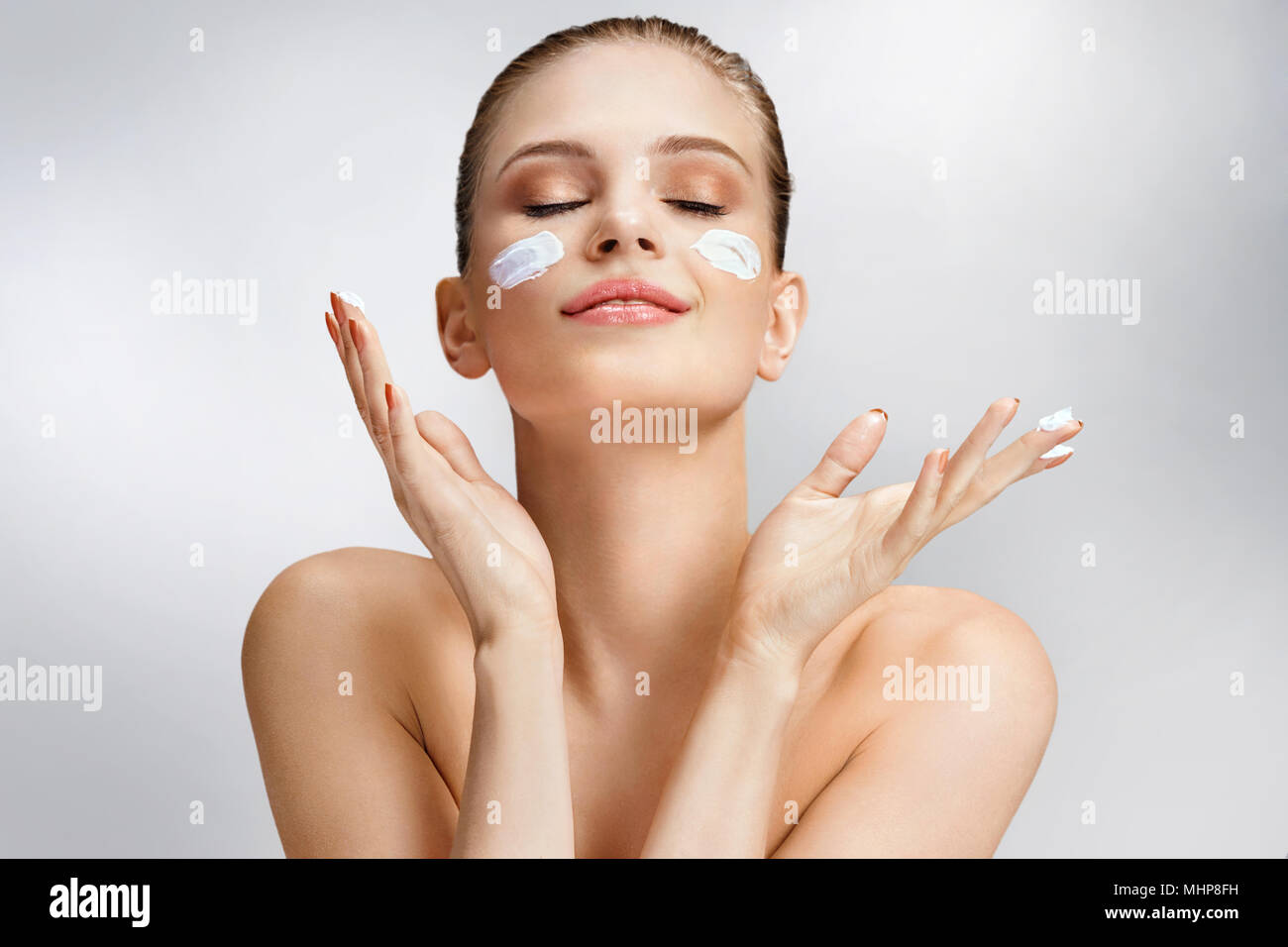 Beautiful Woman Applying Moisturizing Cream On Her Face Photo Of Woman