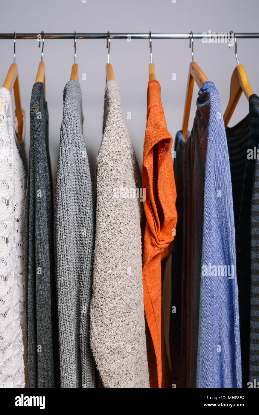 Clothing hanging on a clothing rack in a shop or home closet. Stock Photo