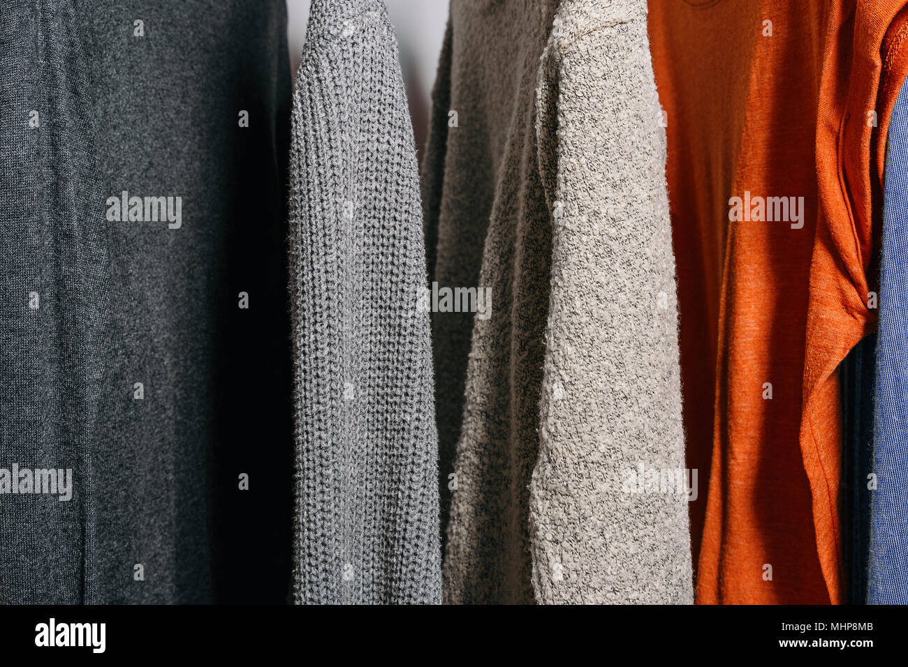 Close up shot of clothing hanging on a clothing rack in a shop or home closet. Stock Photo
