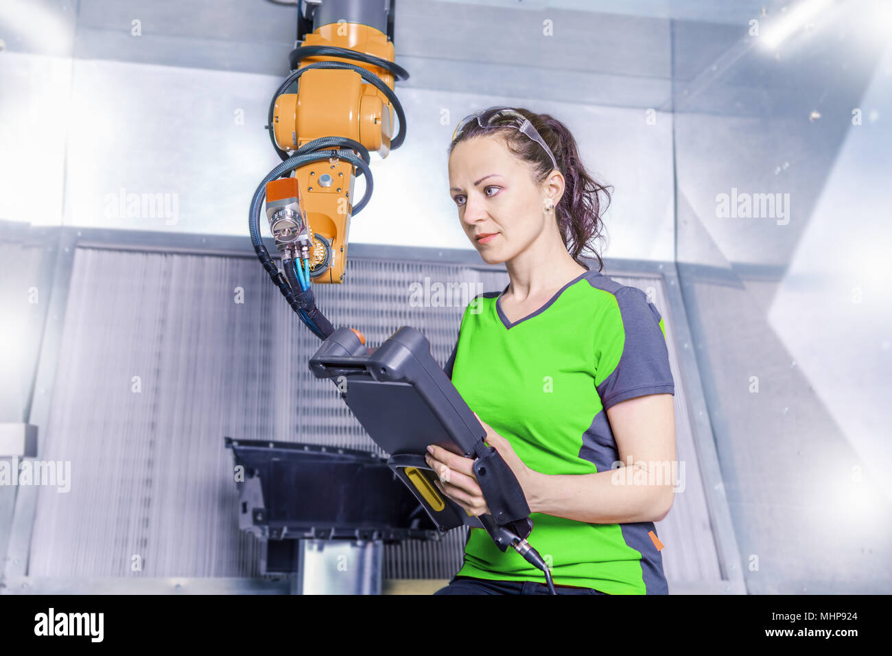 A young female technician while machine constructing in a manufacturing plant Stock Photo
