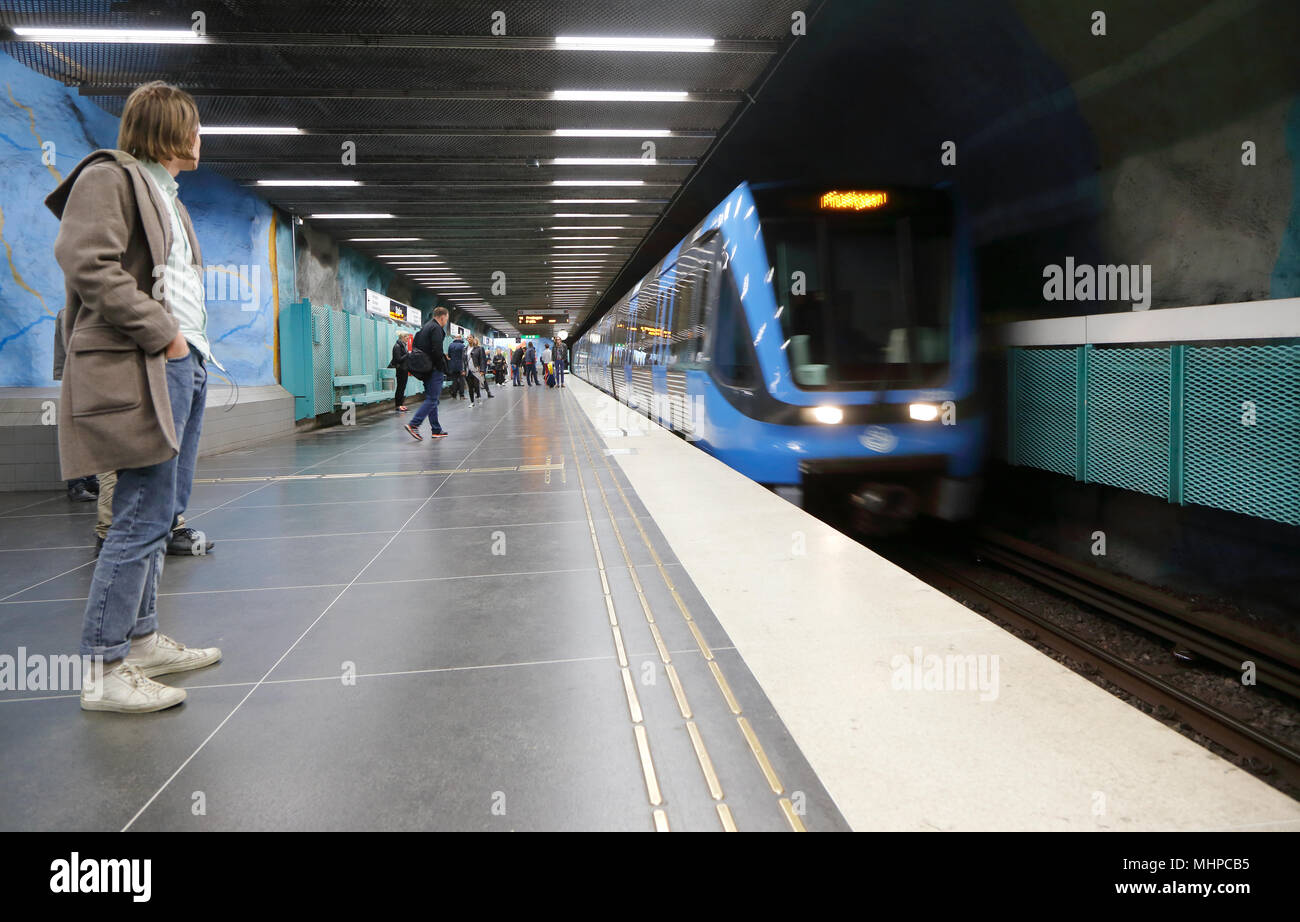 Stockholm, Sweden - April 23, 2014: A blue subway train arrives at the platform at the station Stadion in the Stockholm metro system where a man waiti Stock Photo