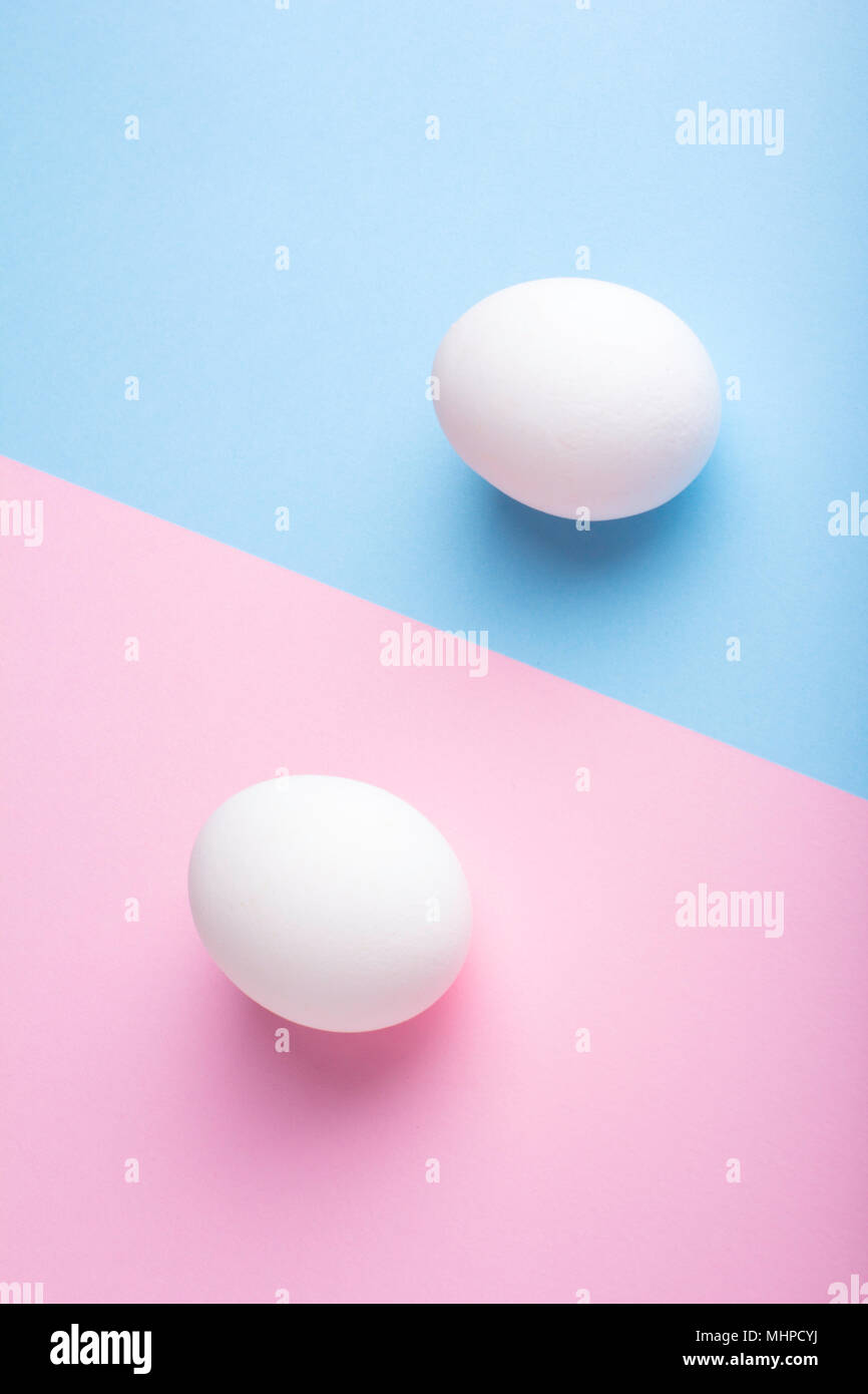 Two eggs on flat lay blue pink paper background Stock Photo