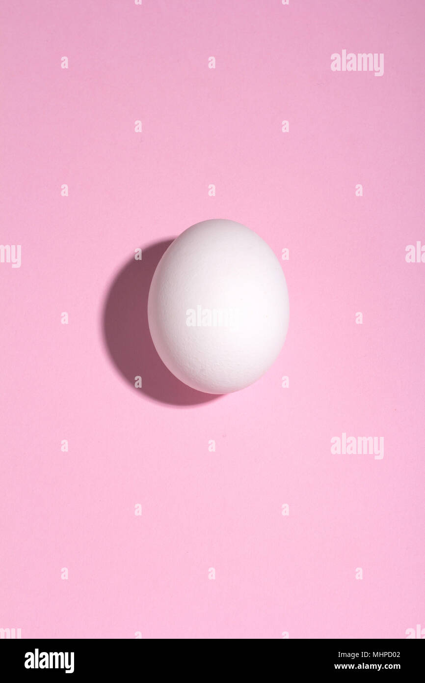 white egg with deep shadow on a pink background Stock Photo