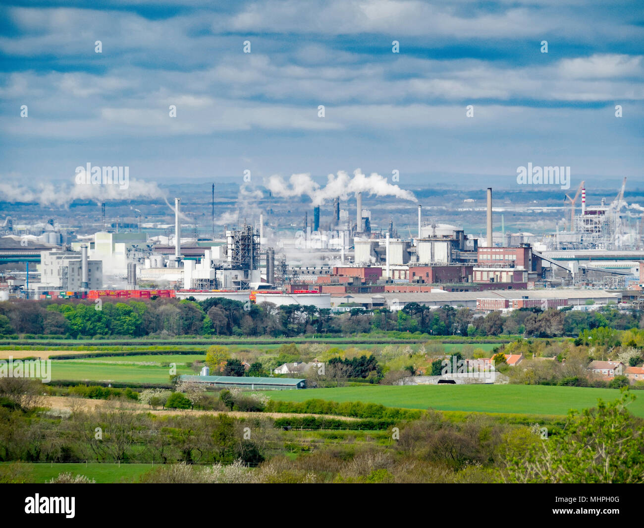 Houses and a farm at Yearby in front of Wilton site chemical plant industry on Teesside Stock Photo