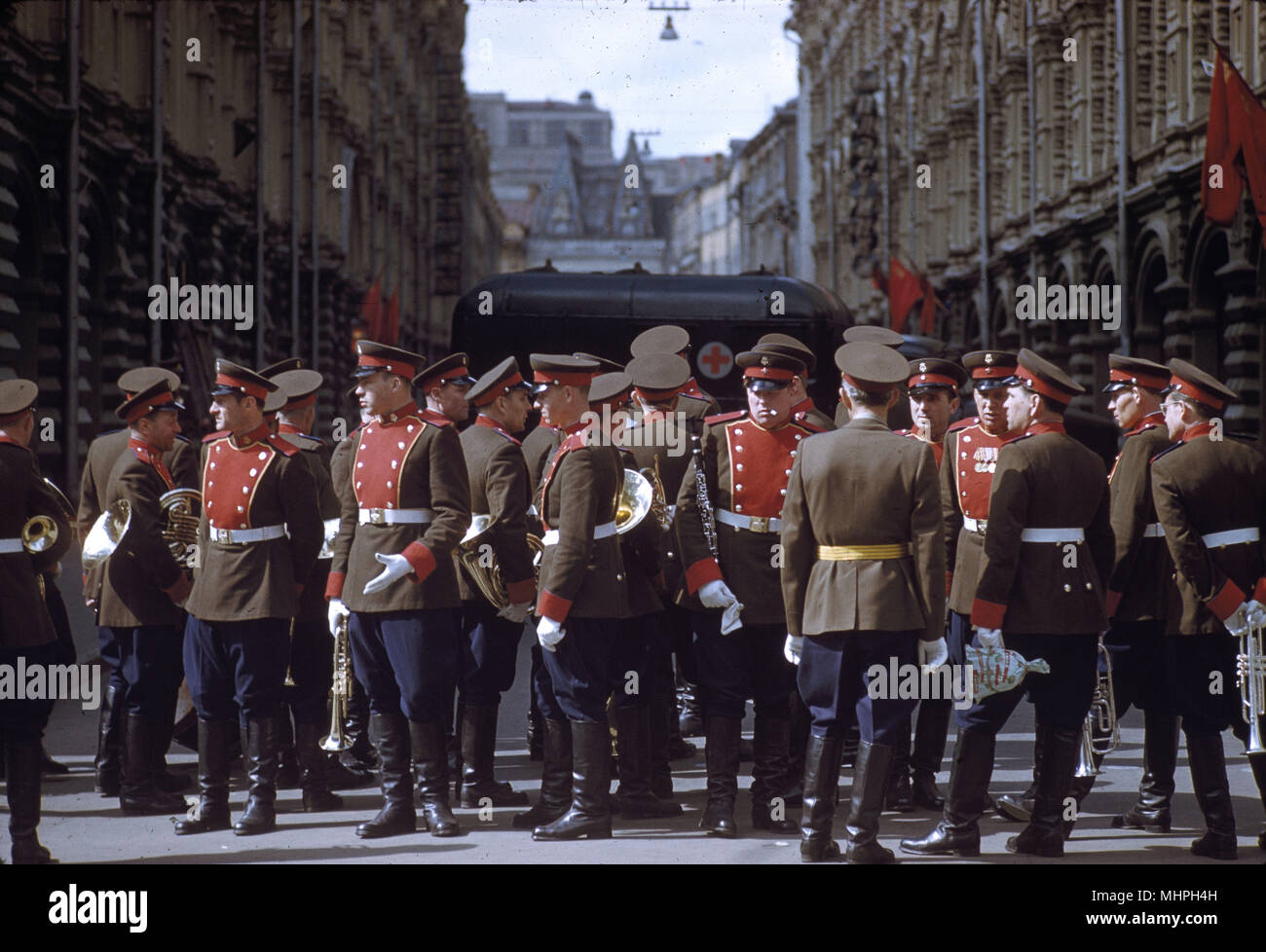 Street scene following the May Day celebrations in Moscow, in 1961 -- soldiers with musical instruments in a narrow street.     Date: 1961 Stock Photo
