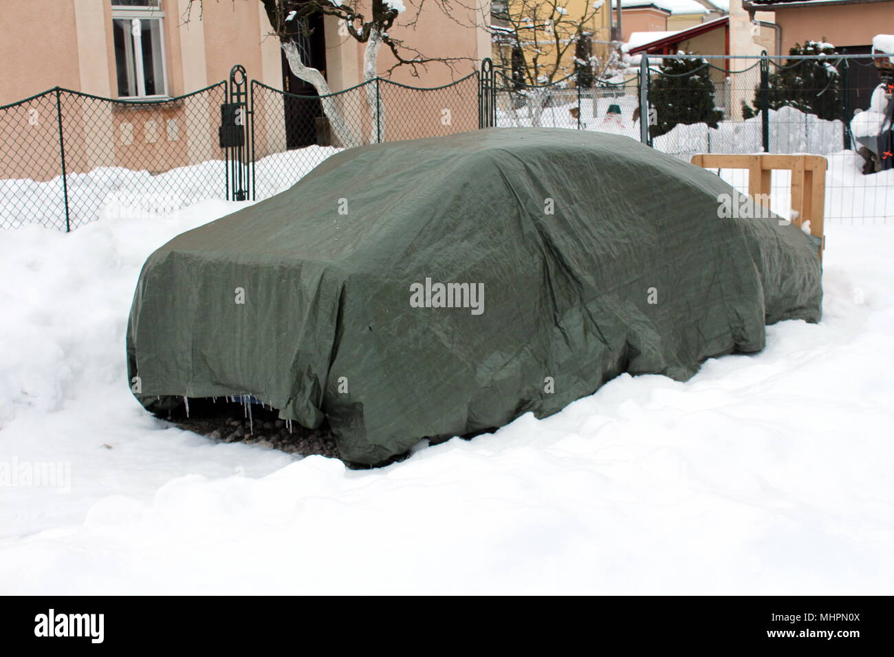 Family car parked in backyard covered with nylon waterproof cover  protection and surrounded with deep snow on cold winter day Stock Photo -  Alamy