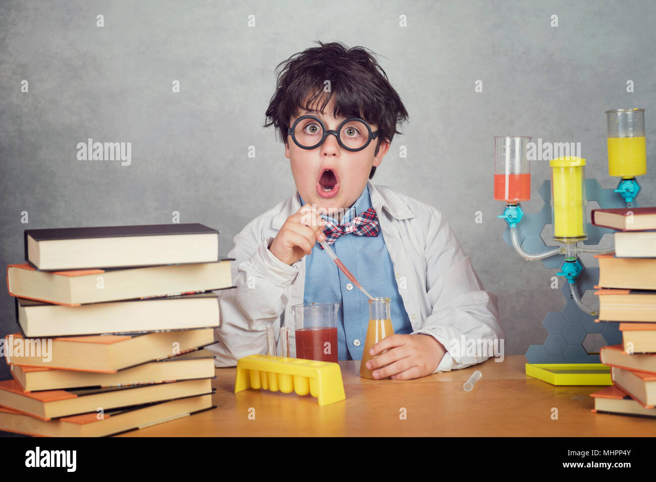 boy is making science experiments in a laboratory on gray background Stock Photo