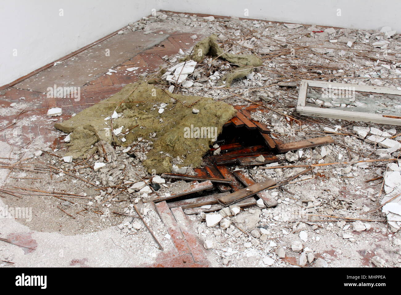 Hardwood floor destroyed by water and covered in rubble, broken