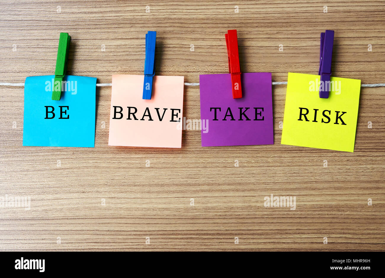 Inspirational quote - Be brave take risk on notes hanging by clothespins Stock Photo