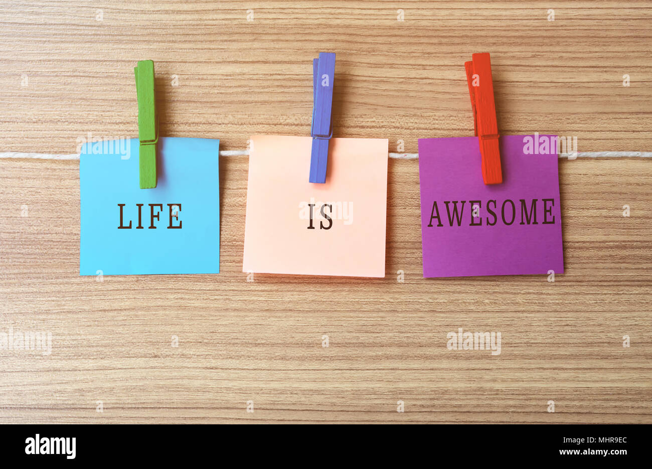 Life is awesome Inspirational quote on notes hanging by clothespins Stock Photo