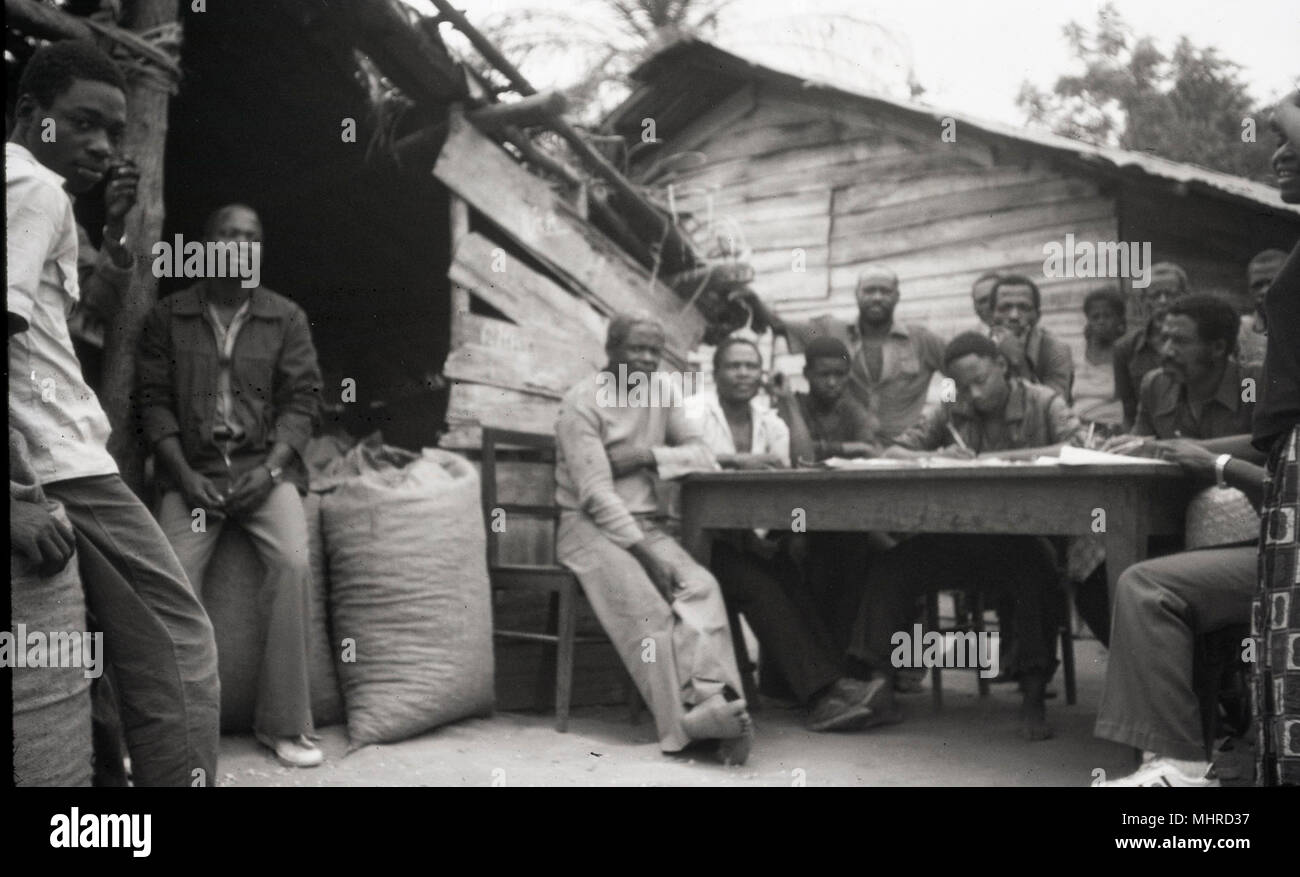 Snapshot of villagers gathered around a table. Stock Photo