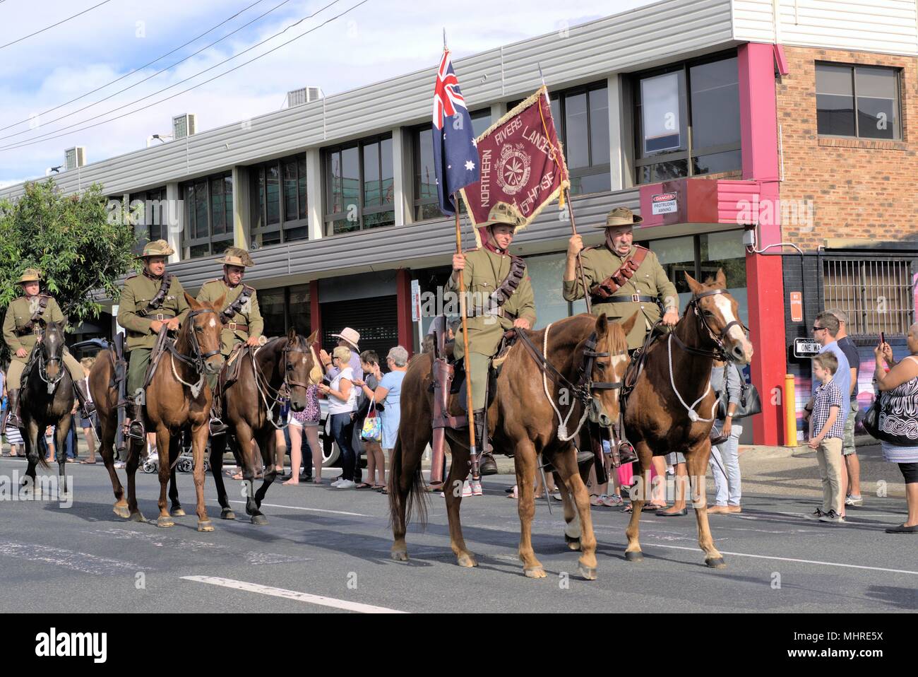 Crowd watch cavalry or horsemen or lancers at ANZAC Day parade in Australian city of Coffs Harbour Stock Photo