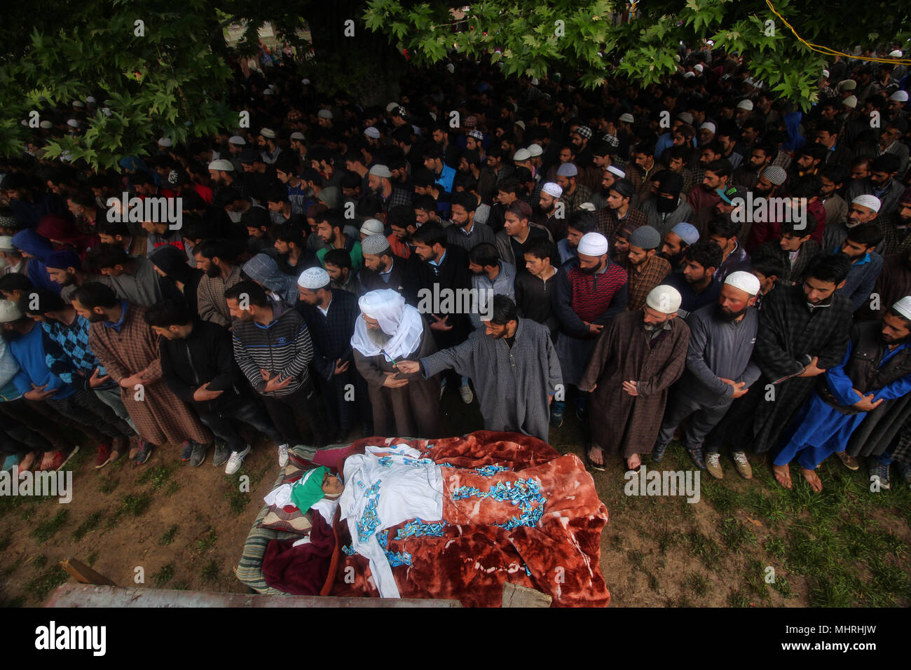 Shopian, Jammu and Kashmir, 3rd May, 2018. School shirt is placed on the body of a teenager, Umar Kumar as people offer funeral prayer in Pinjoora some 50 kilometers from Srinagar the summer capital of Indian controlled Kashmir on May 03, 2018. Umar was shot dead by government forces after the clashes erupt following a gun battle between rebels and Indian forces in Turkewangam area of south Kashmir's Shopian. Later the rebels managed to escape from the site of gun-battle, local residents said. Credit: Faisal Khan/ZUMA Wire/Alamy Live News Stock Photo