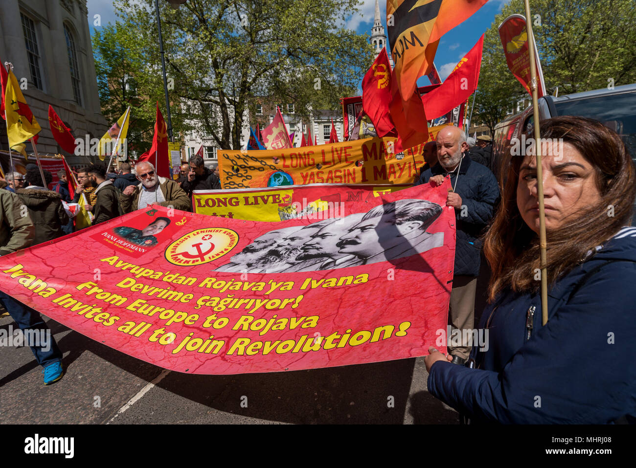 May 1, 2018 - A rally in Trafalgar Square including many .from London's international and migrant communities celebrates .International Workers Day. Some held flags and banners on the plinth of .Nelson's Column  while others listened to the speeches by a number of .trade unionists and activists and included a short silence in memory of .Mehmet Aksoy who was killed in Syria whilst filming with Kurdish .fighters and had spoken for the Kurds at previous events. At the end of .the rally there was a speech by Brixton Ritzy trade unionist Kelly .Rogers victimised by Picturehouse and the various prec Stock Photo