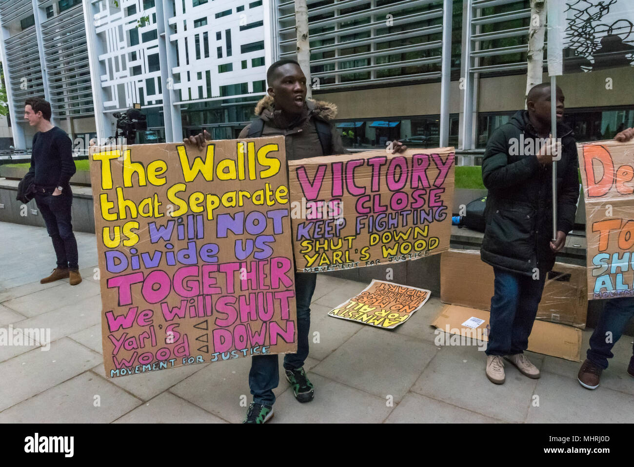 London, UK. May 1, 2018 - London, UK. 1st May 2018. Protesters hold posters and a banner at the Home Office called by Movement for Justice calling for an end to immigration charter flights. The protest was called as the Home Office intends to carry out a mass deportation to Jamaica in the middle of the Windrush scandal including members of the Windrush generation. Credit: ZUMA Press, Inc./Alamy Live News Stock Photo