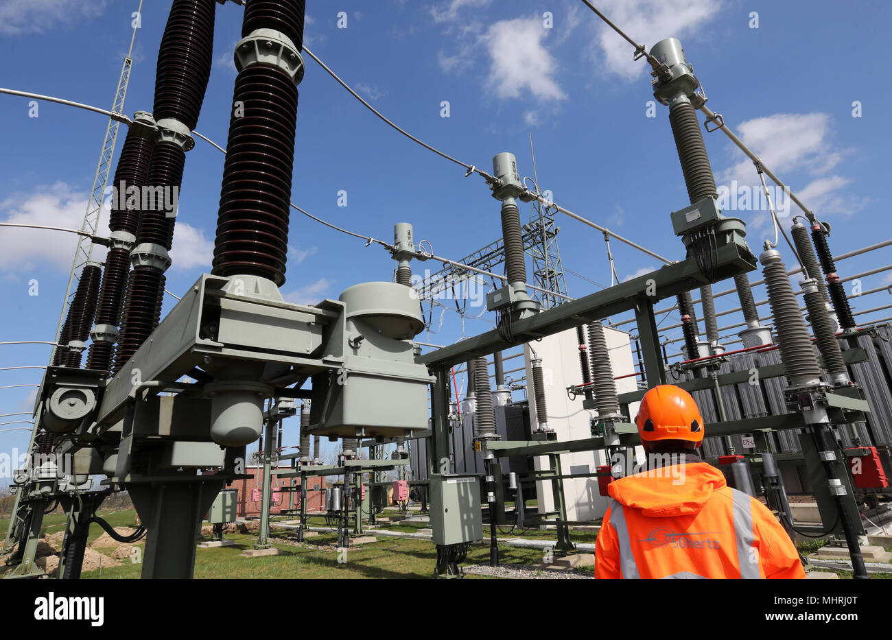 17 April 2018, Germany, Bentwisch: A staff member of grid operator 50Hertz walks through the large switchboard unit at the new transformer substation. The German offshore windparks 'Baltic 1' and 'Baltic 2' and Danish windpark 'Kriegers Flak' both supply the transformer station which connects the powergrids in Germany and Denmark with electricity. The Scandinavian and German powergrids are not synchronised and the transformer converts arriving electricity from the windparks in direct current and switching back again into alternating currents but with a different frequency, which compliant wit Stock Photo