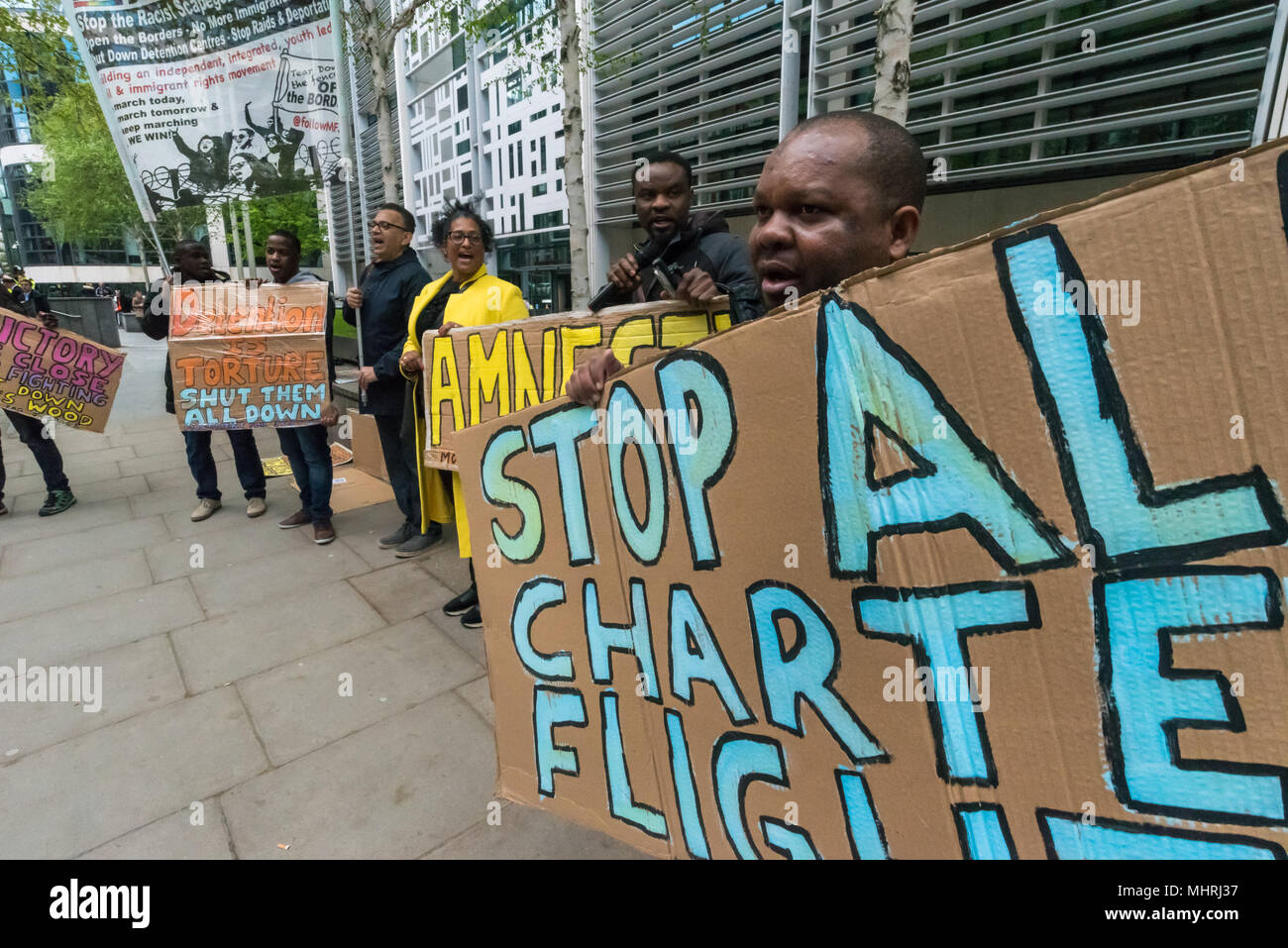 May 1, 2018 - London, UK. 1st May 2018. Protesters hold posters and a banner at the Home Office called by Movement for Justice calling for an end to immigration charter flights. The protest was called as the Home Office intends to carry out a mass deportation to Jamaica in the middle of the Windrush scandal including members of the Windrush generation. The protest at the Home Office and later at the Jamaican High Commission called for an end to these mass deportations, which have led to a rounding up of many who are in this country legally but whose cases are still disputed by the Home Office. Stock Photo