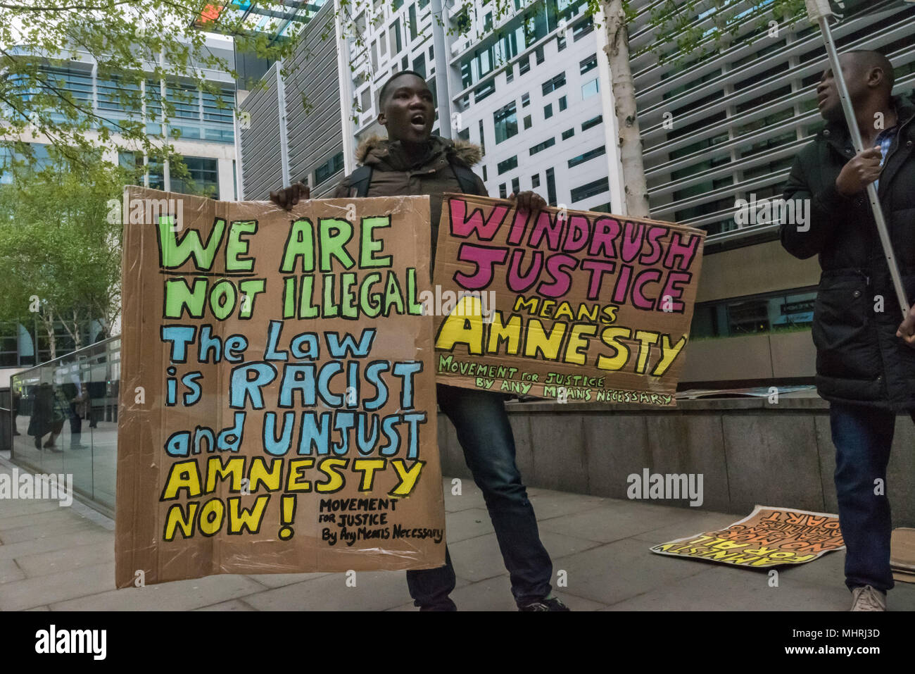 May 1, 2018 - London, UK. 1st May 2018. Protesters hold posters and a banner at the Home Office called by Movement for Justice calling for an end to immigration charter flights. The protest was called as the Home Office intends to carry out a mass deportation to Jamaica in the middle of the Windrush scandal including members of the Windrush generation. The protest at the Home Office and later at the Jamaican High Commission called for an end to these mass deportations, which have led to a rounding up of many who are in this country legally but whose cases are still disputed by the Home Office. Stock Photo