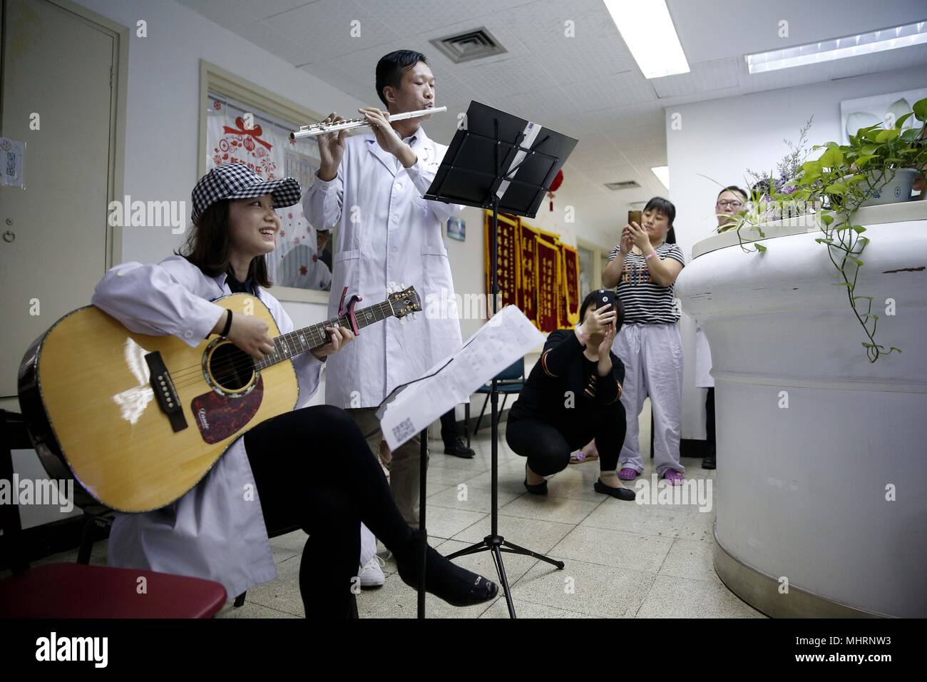 (180503) -- BEIJING, May 3, 2018 (Xinhua) -  Members of the 'Xieyun' orchestra perform in a ward of Peking Union Medical College Hospital (PUMCH) in Beijing, capital of China, April 23, 2018. In 2015, PUMCH doctors and Peking Union Medical College students launched the 'Xieyun' orchestra. Every month, members of 'Xieyun' would voluntarily stage one or two musical performances for patients, their families, and other medical workers. The orchestra was widely appreciated by its audiences for its performances and the members' concern and love for the patients. (Xinhua/Zhang Yuwei) (lb) (zt) Stock Photo