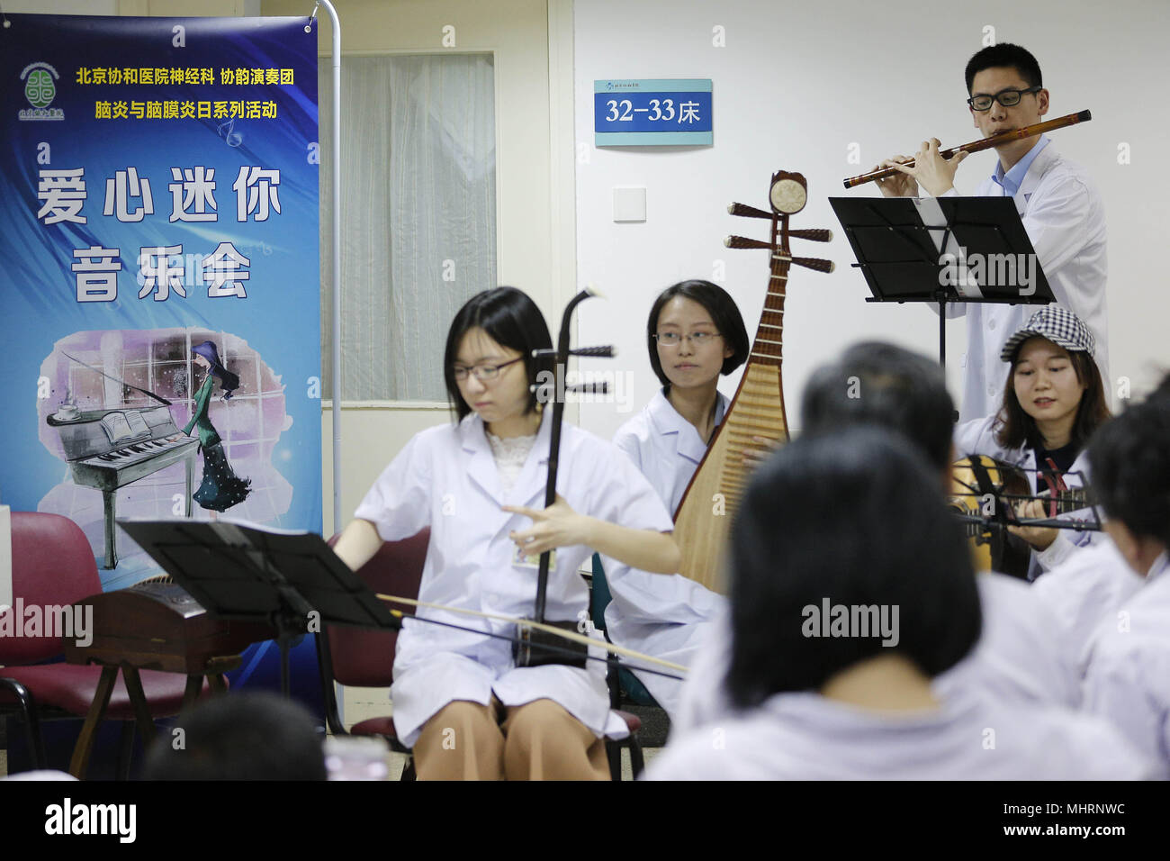 (180503) -- BEIJING, May 3, 2018 (Xinhua) -  Members of the 'Xieyun' orchestra perform in a ward of Peking Union Medical College Hospital (PUMCH) in Beijing, capital of China, April 23, 2018. In 2015, PUMCH doctors and Peking Union Medical College students launched the 'Xieyun' orchestra. Every month, members of 'Xieyun' would voluntarily stage one or two musical performances for patients, their families, and other medical workers. The orchestra was widely appreciated by its audiences for its performances and the members' concern and love for the patients. (Xinhua/Zhang Yuwei) (lb) (zt) Stock Photo