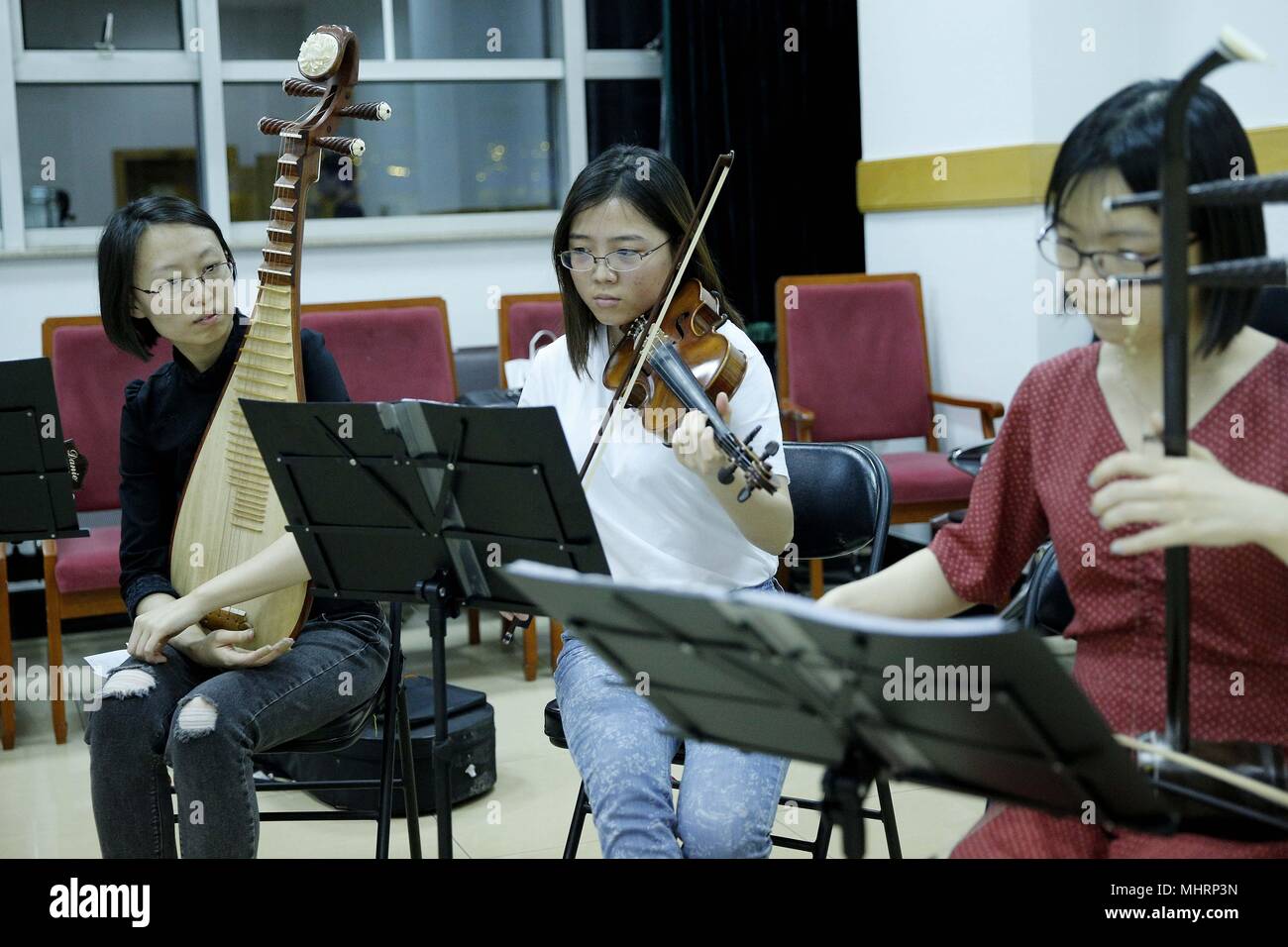 (180503) -- BEIJING, May 3, 2018 (Xinhua) - Medical student He Yumiao (C) and fellow members of the 'Xieyun' orchestra attend a rehearsal at Peking Union Medical College (PUMC) in Beijing, capital of China, May 2, 2018. In 2015, Peking Union Medical College Hospital doctors and PUMC students launched the 'Xieyun' orchestra. Every month, members of 'Xieyun' would voluntarily stage one or two musical performances for patients, their families, and other medical workers. The orchestra was widely appreciated by its audiences for its performances and the members' concern and love for the patients. Stock Photo