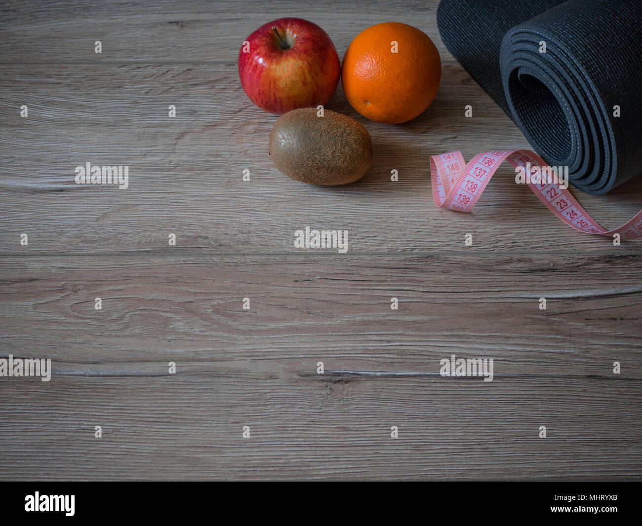 Fitness and Sport Consept. Women items for sports. Measuring tape, centimeter. The concept of sport for weight loss. Bottle of water. Fruits. Flatlay. Stock Photo