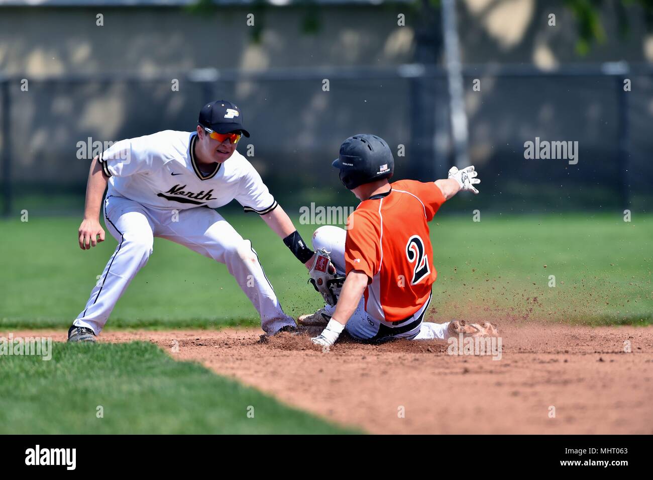 Shortstop applying a tag on a baserunner too late to prevent him from advancing to second on a wild pitch. USA. Stock Photo