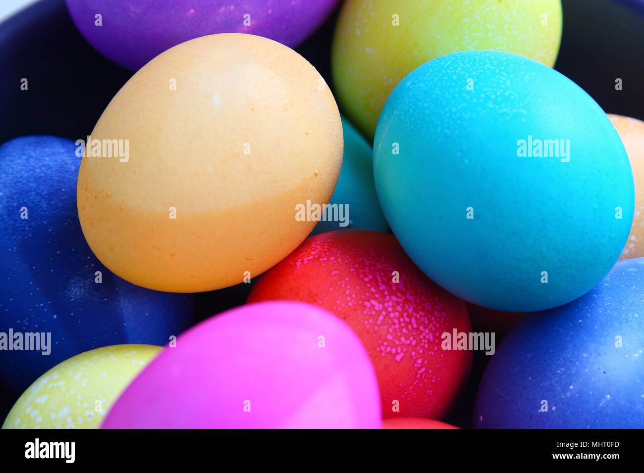 Group of eggs brightly colored for easter, in a pile, close-up Stock Photo