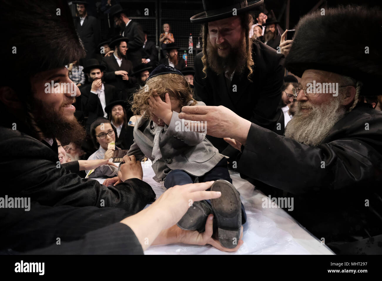 A three-year old Jewish boy takes part in the traditional Halake ceremony, a first hair cut from the Rabbi of the Pinsk-Karlin Hassidic dynasty in Geula religious neighborhood during the celebration of Lag BaOmer holiday which marks the celebration, interpreted by some as anniversary of death of Rabbi Shimon bar Yochai, one of Judaism's great sages some 1800 years ago and the day on which he revealed the deepest secrets of kabbalah a landmark text of Jewish mysticism Stock Photo