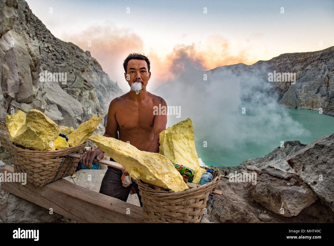 Java Blue Flames JAVA, INDONESIA - AUGUST, 9, 2016 - Miners are carrying sulfur from ...