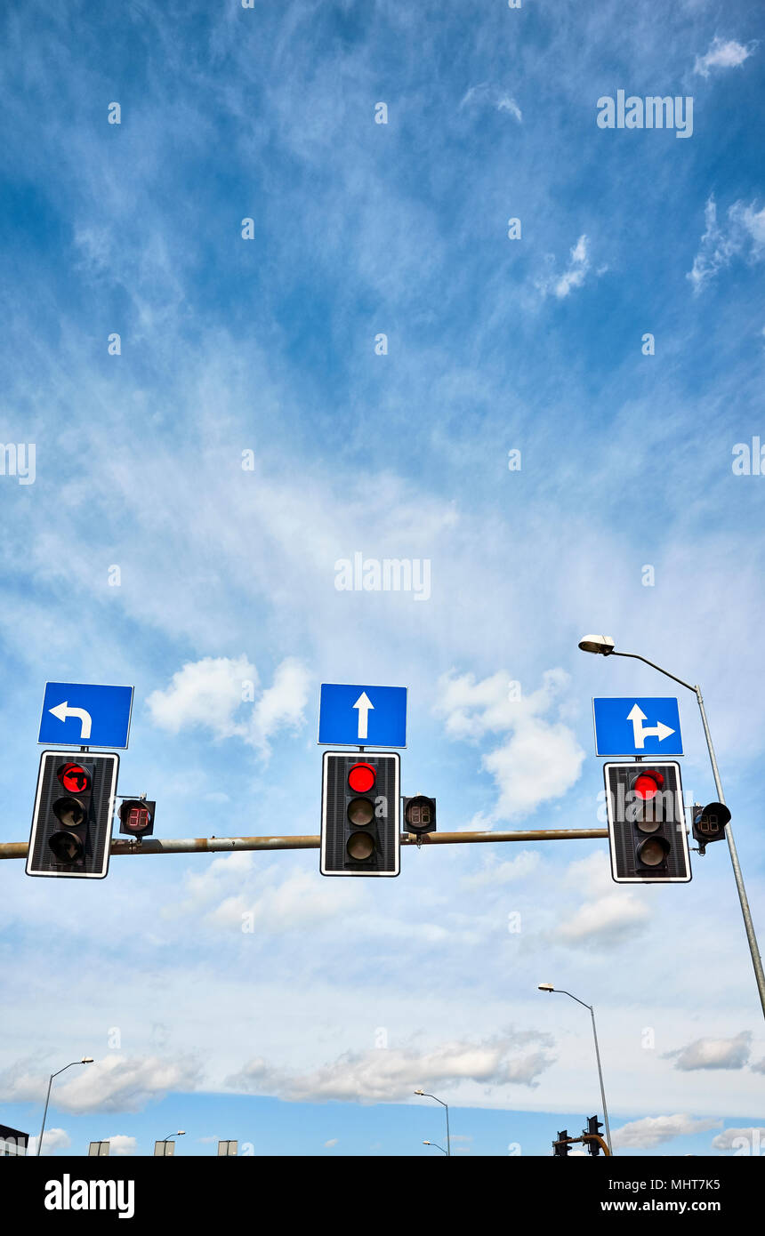 Traffic lights with countdown timers, red color displayed against the blue sky, space for text. Stock Photo