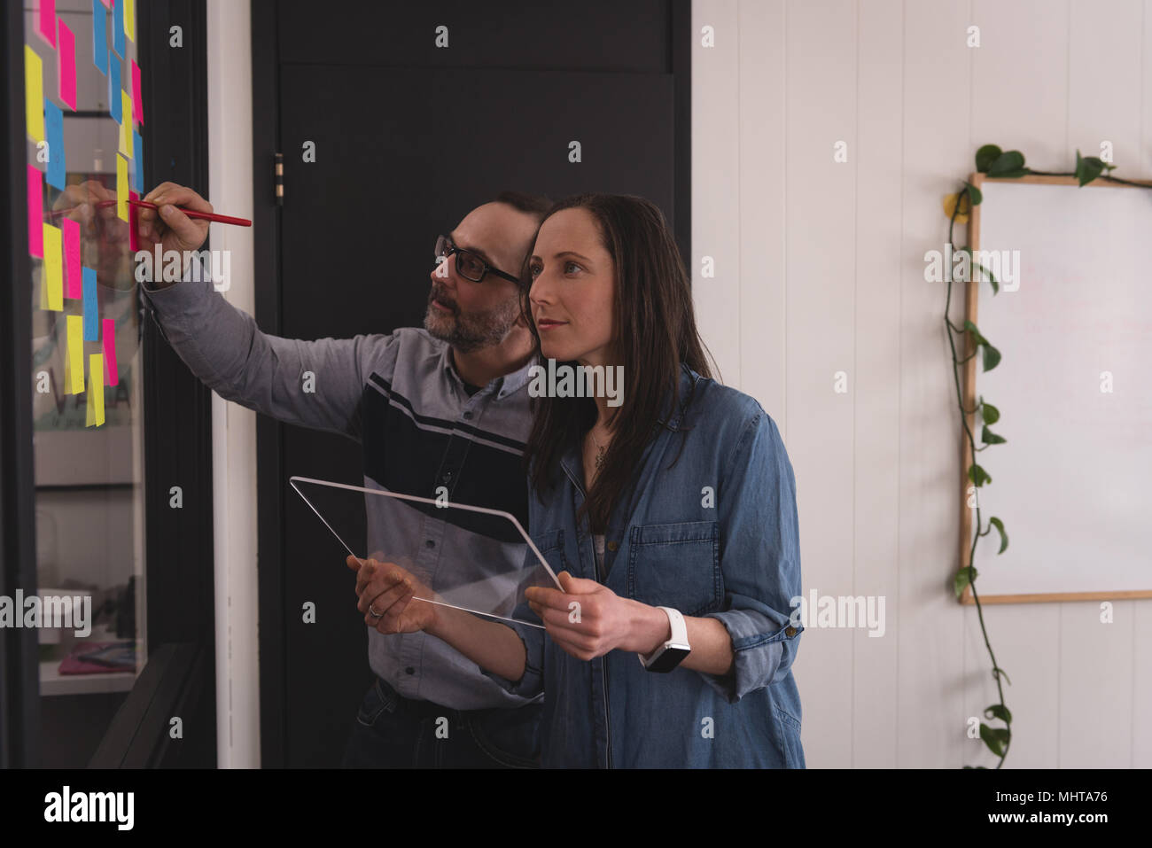 Business colleagues writing on sticky notes Stock Photo