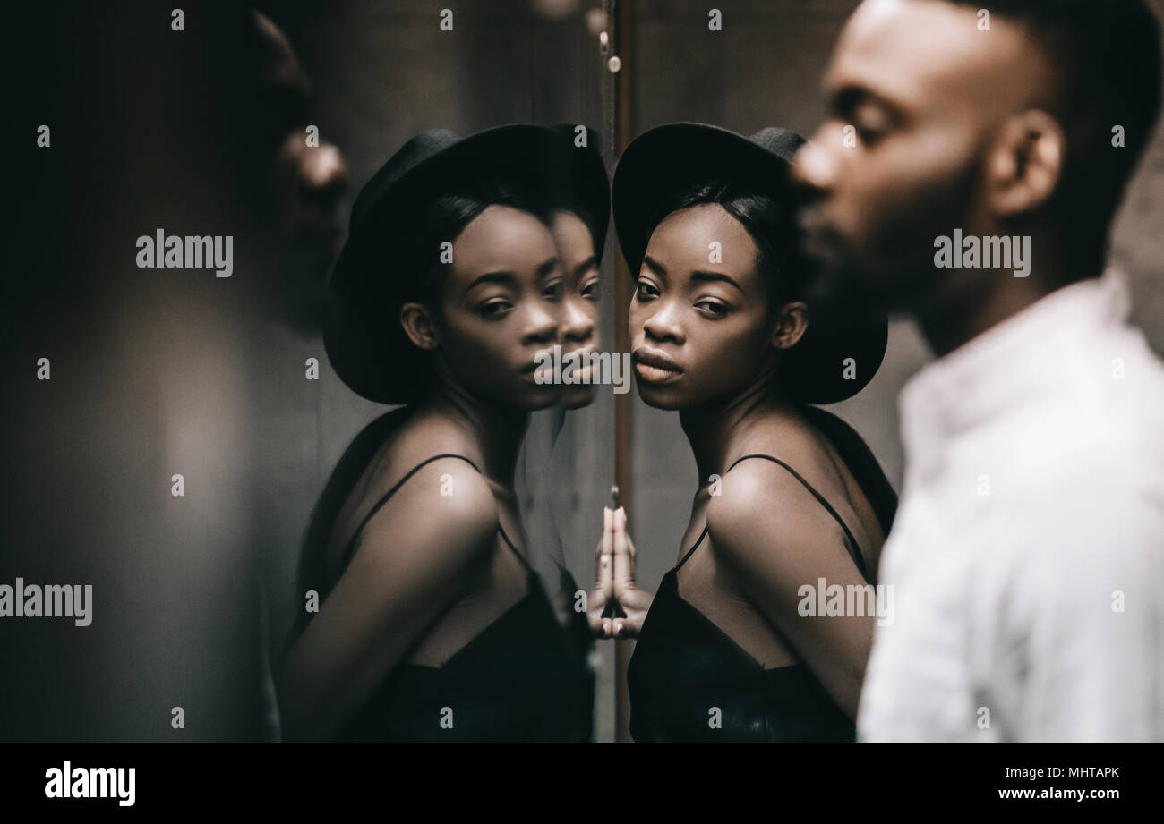 stylish Lovely african newlyweds posing at big mirror in hotel room