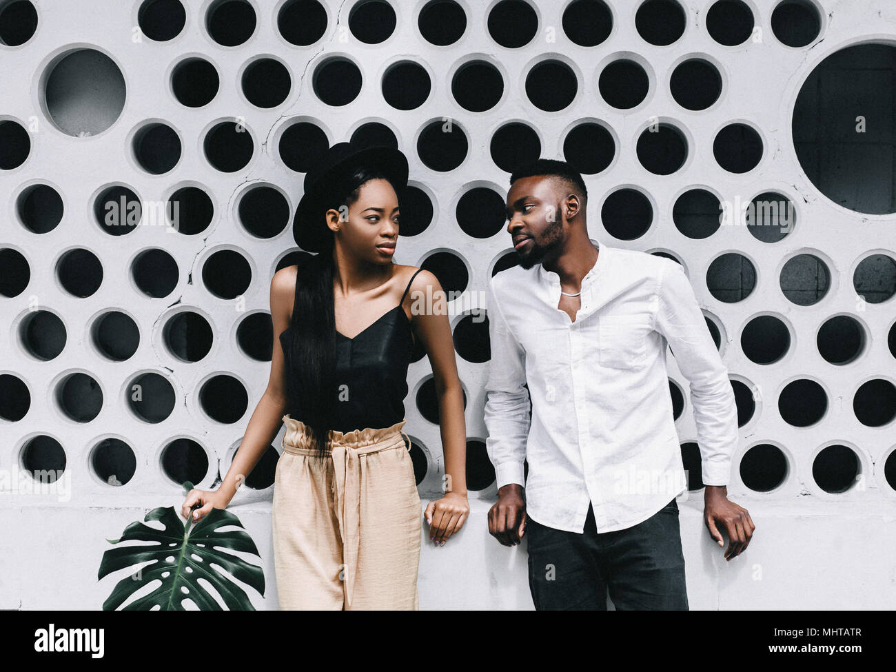 Beautiful young Afro American couple is looking at camera and smiling, on gray background Stock Photo