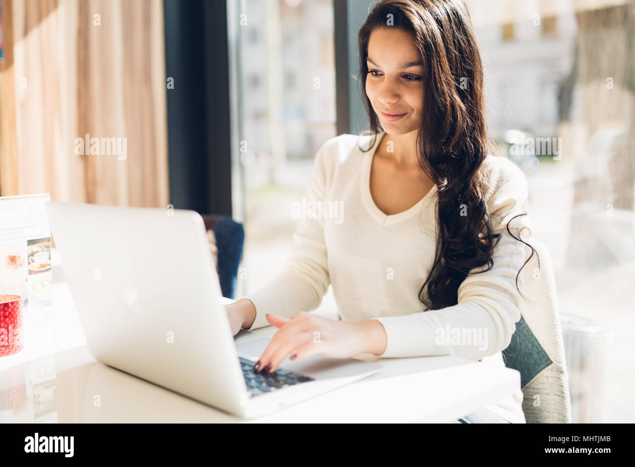 Beautiful brunette using notebook Stock Photo - Alamy