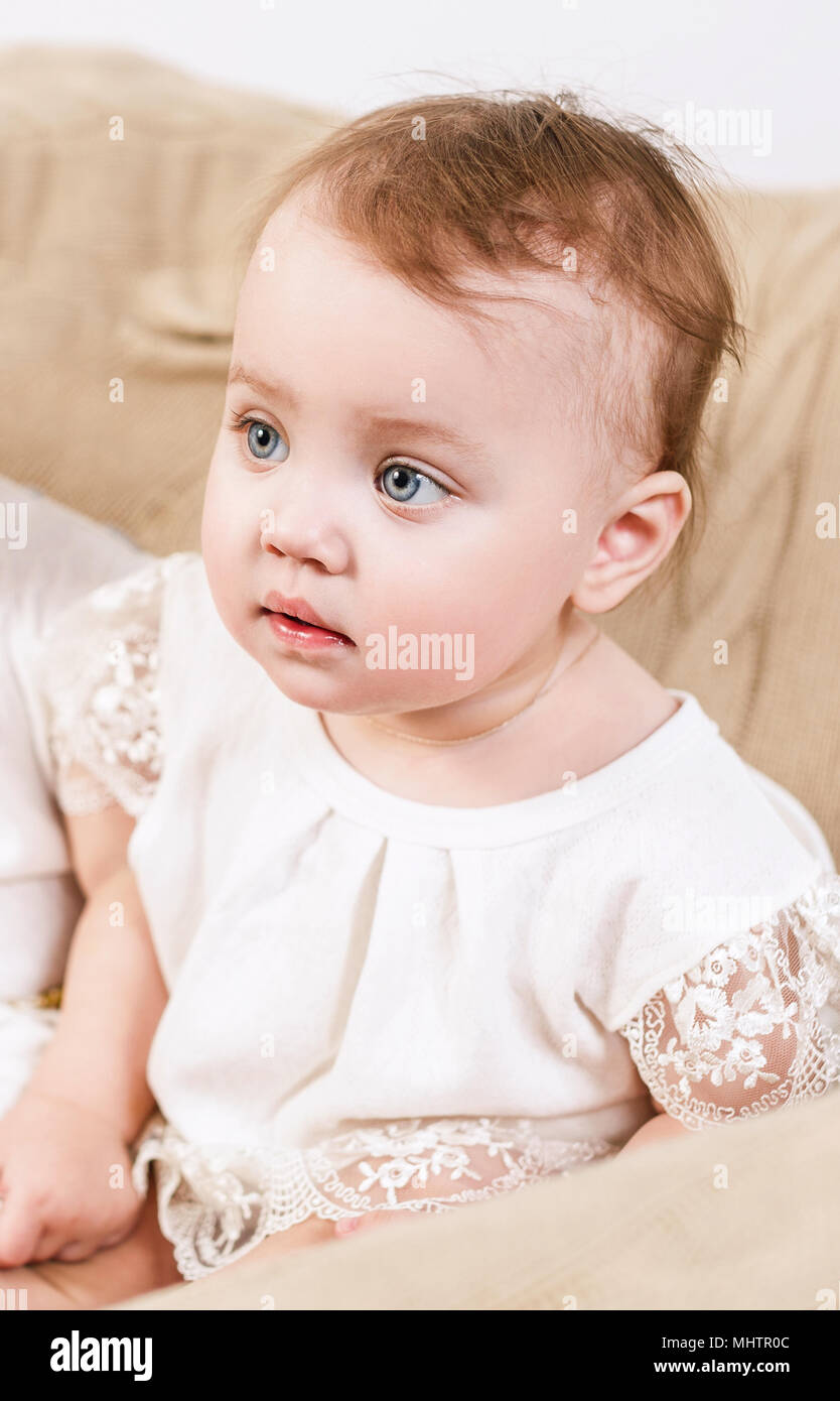 Cute little baby girl sitting in the chair. Stock Photo