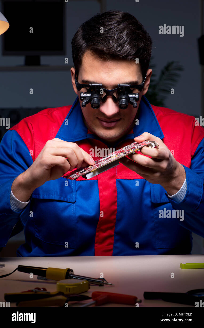 Computer specialist repairing PC late at night Stock Photo - Alamy