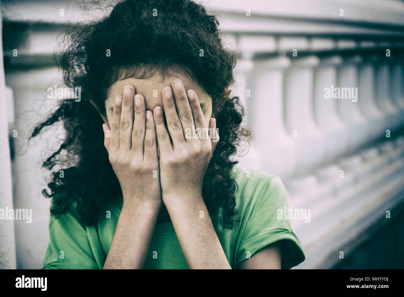 Scared girl hiding face with hands Stock Photo