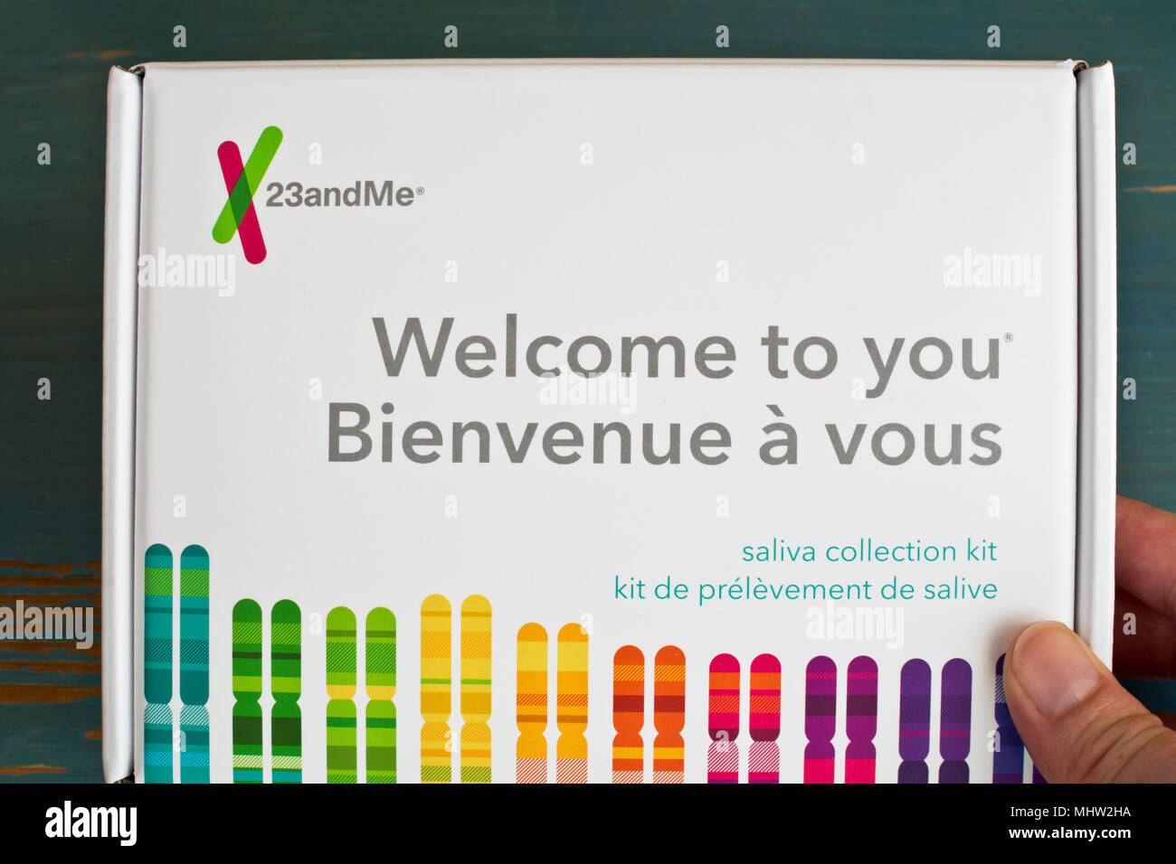 Hand holding 23andMe DNA testing kit box. Home DNA test kit. Stock Photo