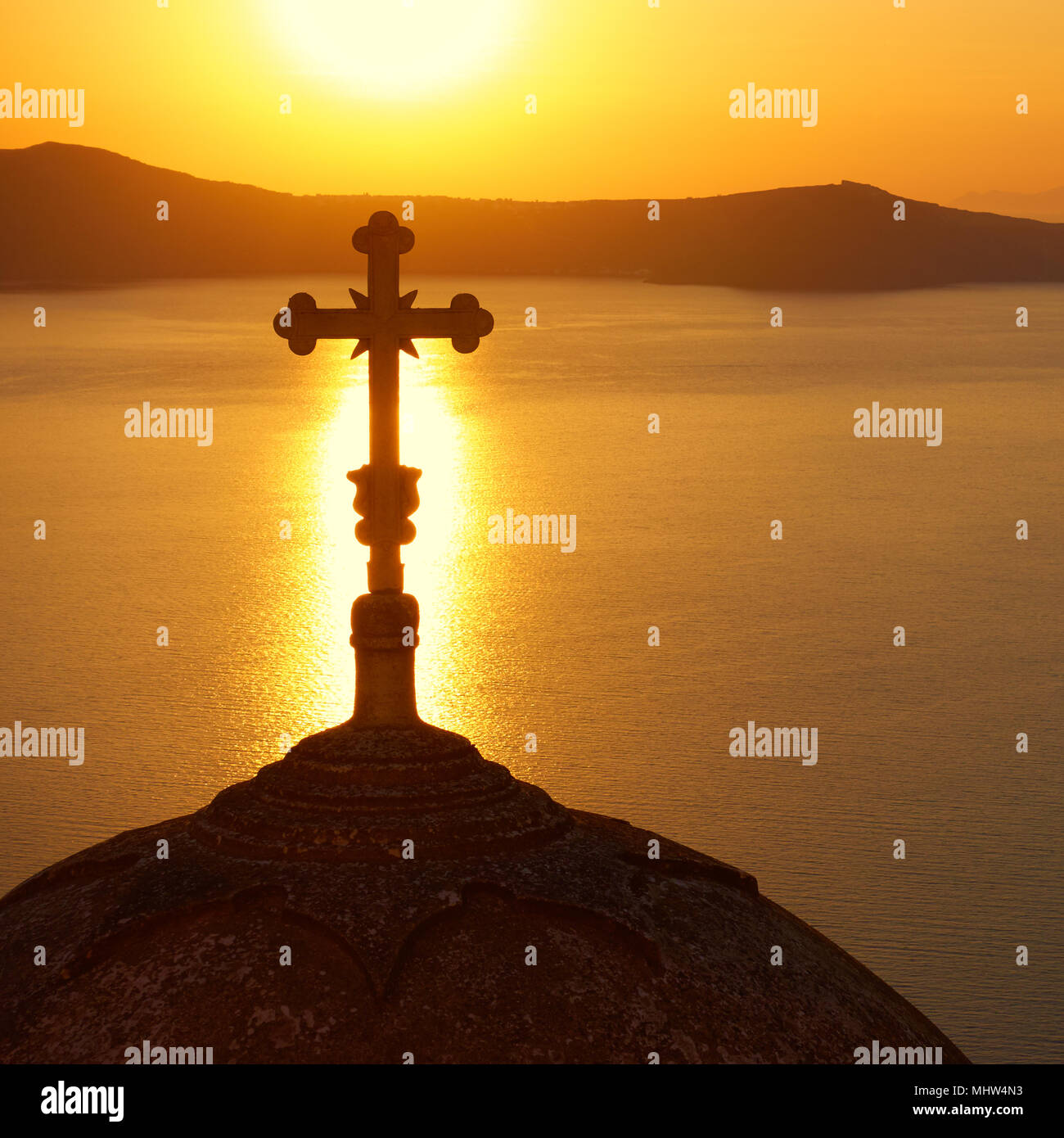 Silhouette of the dome with cross of a Greek orthodox church in Thira in Santorini at sundown, Greece Stock Photo