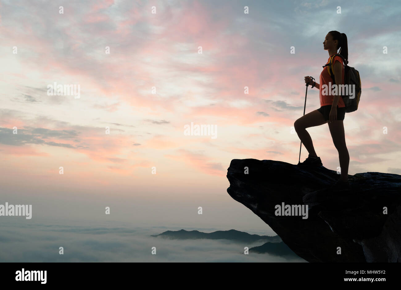 Young woman standing in the top of the mountain Stock Photo - Alamy