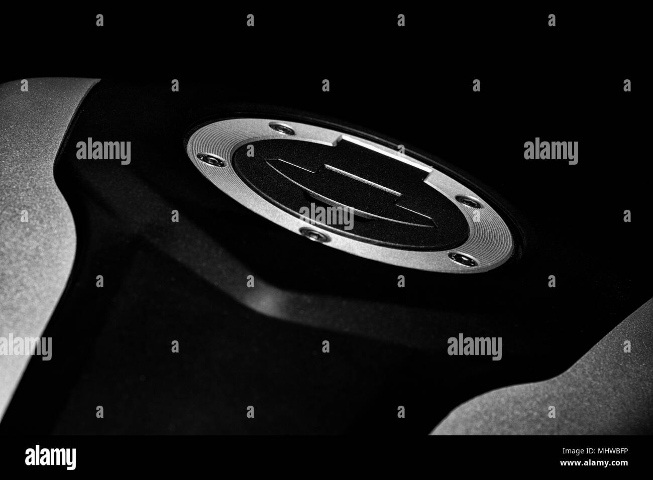 A black and white image of a motorcycle fuel cap situated in a the fuel tank. Stock Photo