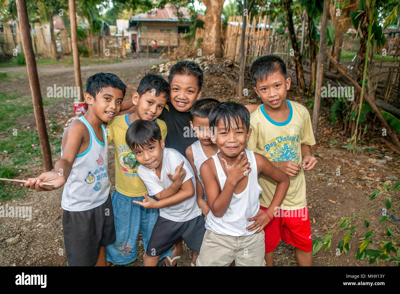 A small group of young Filipino boys ham it up for the camera in a rural area of Puerto Princesa, Palawan, Philippines. Filipinos LOVE to have their p Stock Photo
