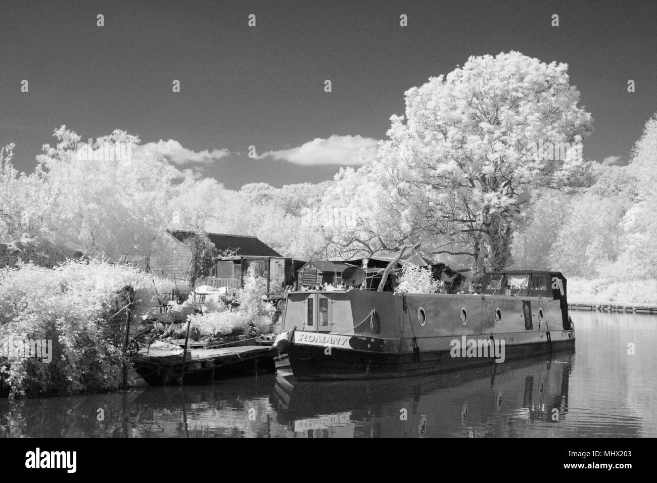 Monochrome infrared image of a pair of narrowboats on the Grand Union Canal, Leighton Buzzard, Bedfordshire, UK. Stock Photo