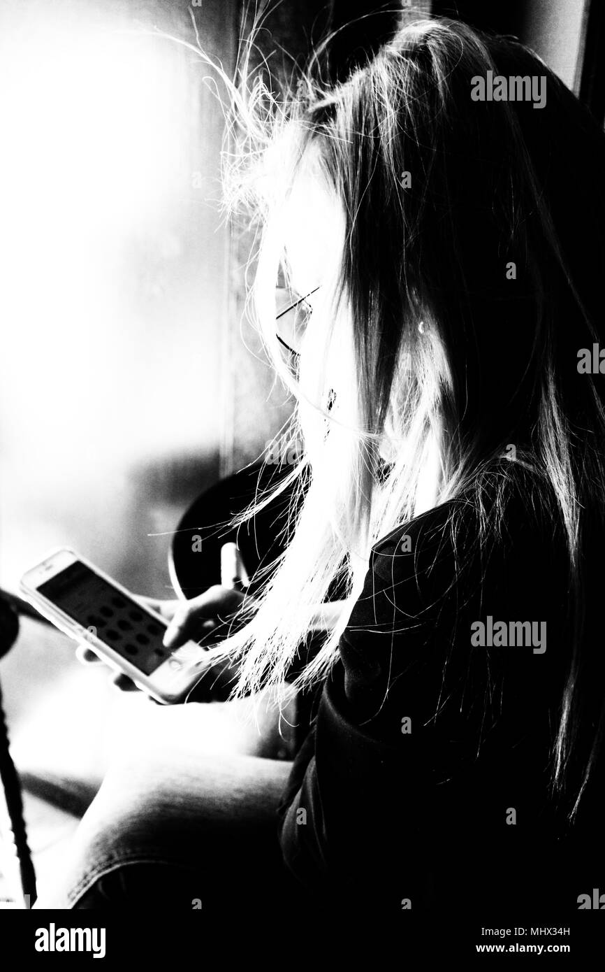 Long hair woman sitting using mobile phone Stock Photo